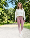 Lachende vrouw in roze 3D shaping legging in een zonnig park
