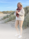 Lachende vrouw in nude thermo legging in de duinen