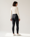 Vrouw draagt de zwarte Contoura Thermo Shaping Legging, achteraanzicht op lichte achtergrond
