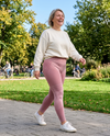 Lachende vrouw in roze 3D shaping legging wandelt door een zonnig park