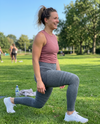 Sportieve vrouw doet lunges in grijze 3D shaping legging tijdens bootcamp in het park